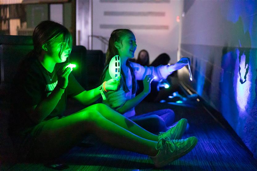 Students use hand lights in the theater